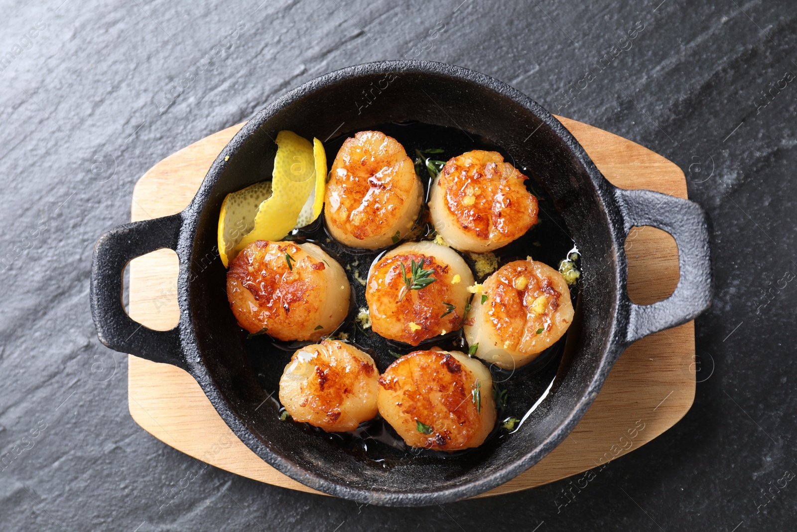 Photo of Delicious fried scallops on dark gray textured table, top view