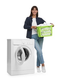 Beautiful woman with laundry basket near washing machine on white background