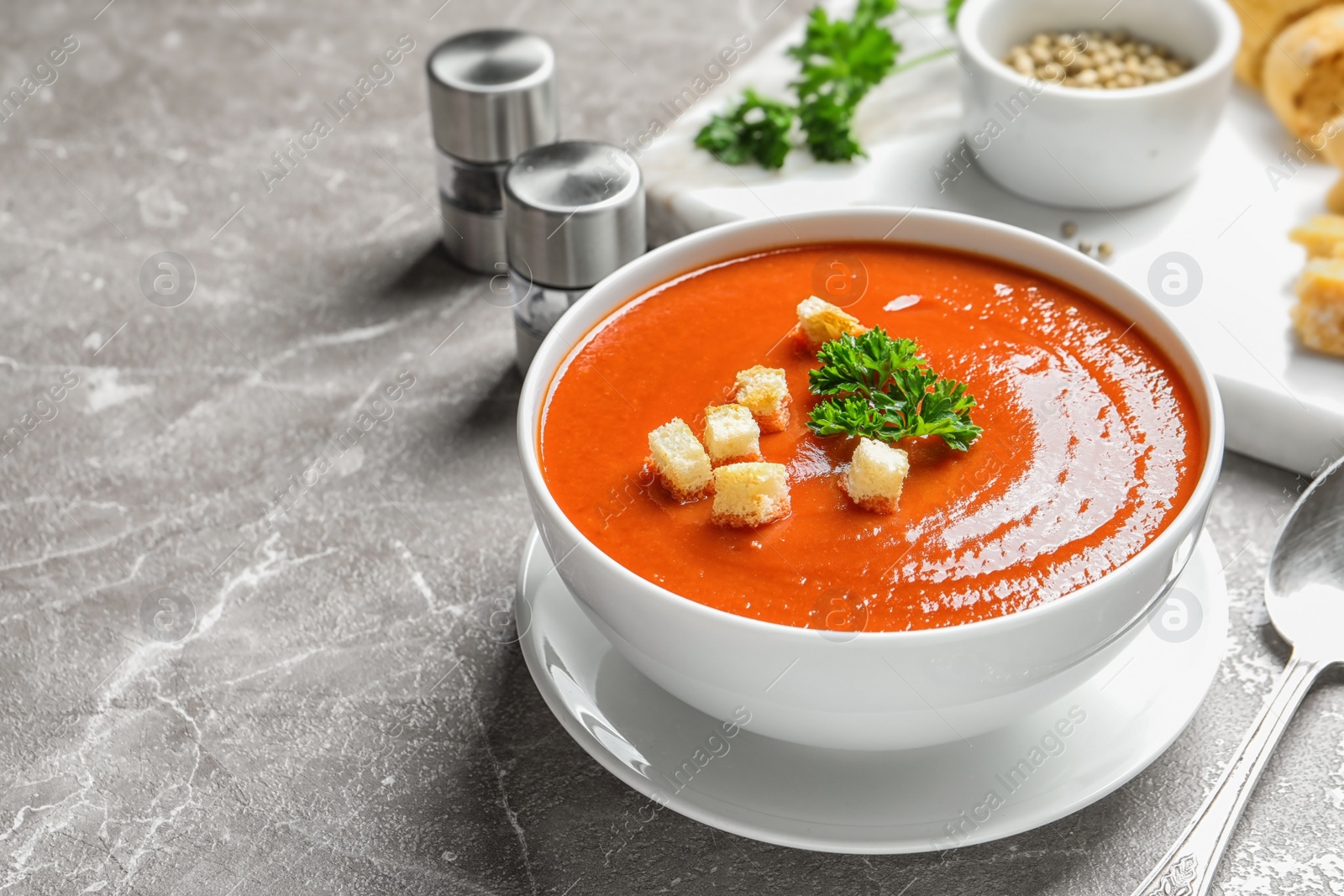 Photo of Bowl with delicious fresh homemade tomato soup on table. Space for text