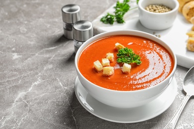 Bowl with delicious fresh homemade tomato soup on table. Space for text