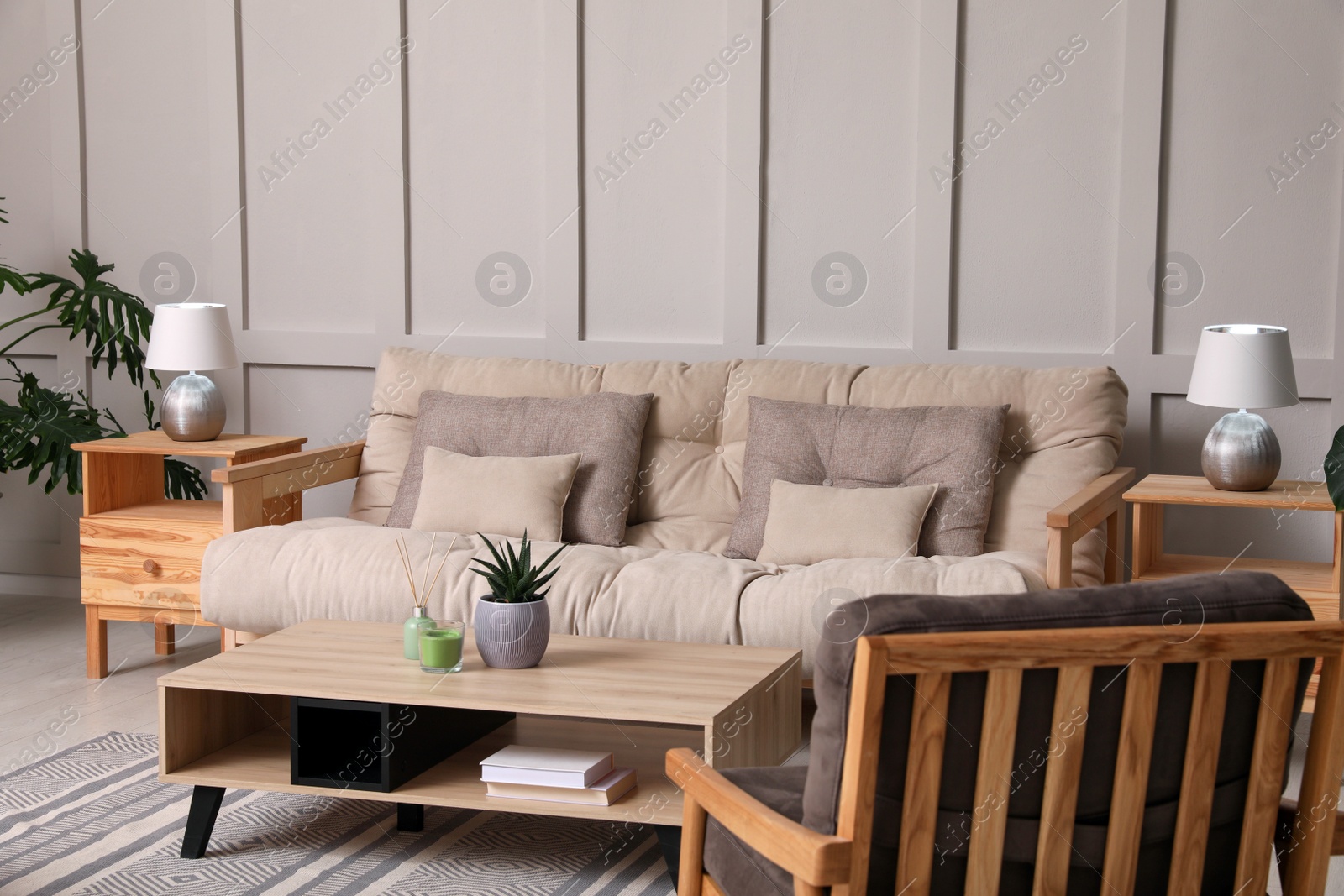 Photo of Stylish living room interior with comfortable sofa, armchair and beautiful plants