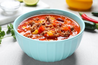 Bowl with tasty chili con carne on white table