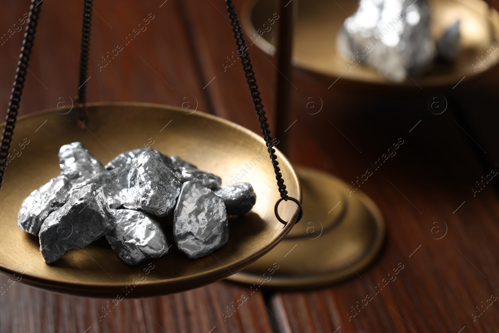 Photo of Vintage scales with silver nuggets on wooden table, closeup