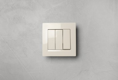 Photo of Modern white plastic light switch on wall