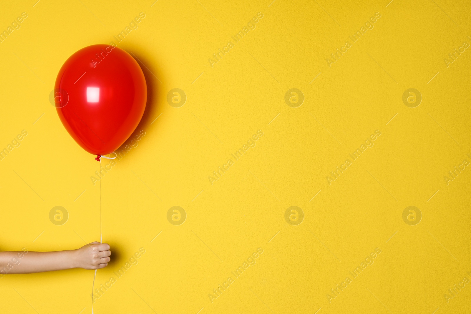 Photo of Woman holding red balloon on color background