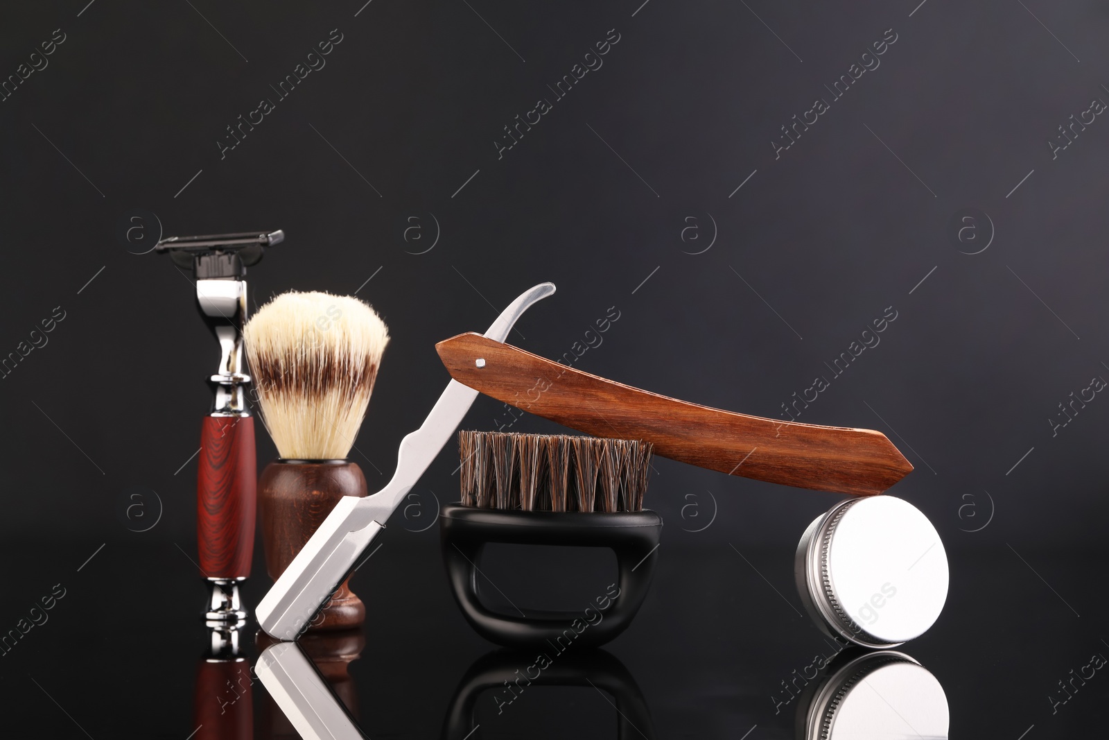 Photo of Moustache and beard styling tools on black mirror surface