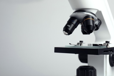 Closeup view of modern microscope on grey background, space for text. Medical equipment