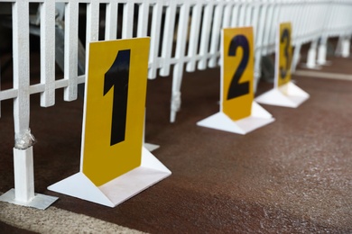 Photo of Yellow signs with numbers and white fence prepared for dog show