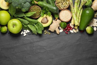 Photo of Flat lay composition with different vegetables, seeds and fruits on black table, space for text. Healthy diet