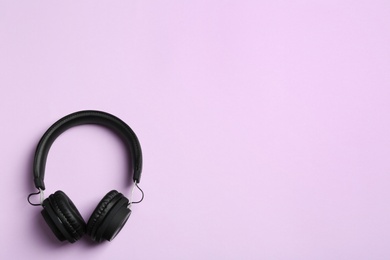 Stylish headphones on color background, top view. Space for text