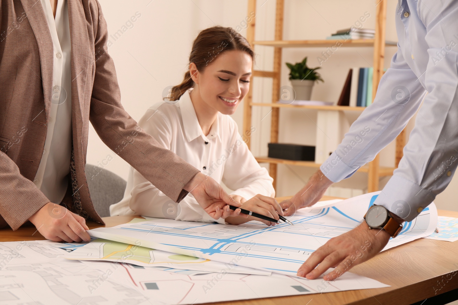 Photo of Professional cartographers working with cadastral map at table in office