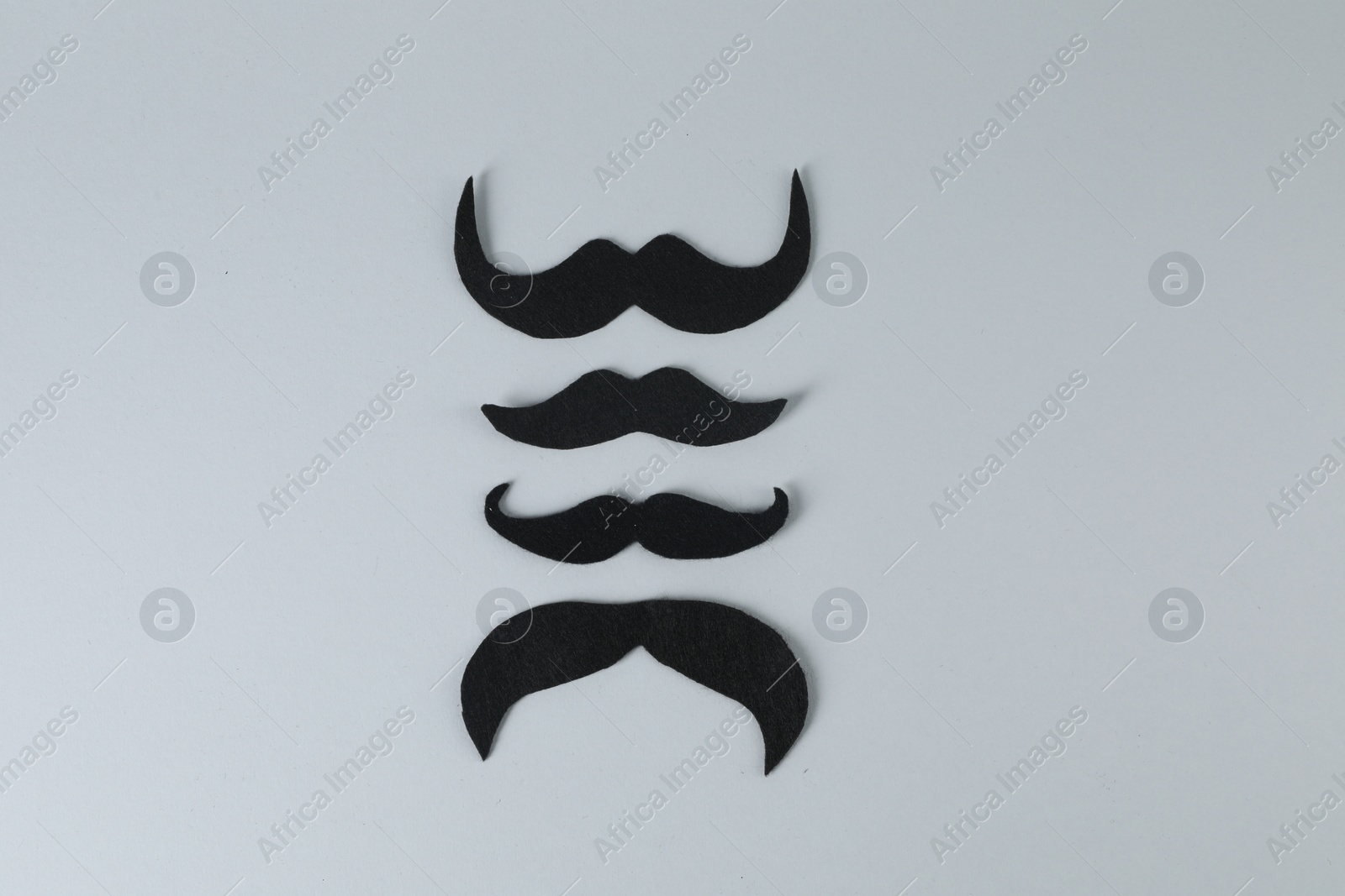 Photo of Fake paper mustaches on grey background, flat lay