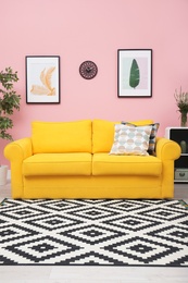 Photo of Modern living room interior with comfortable yellow sofa near color wall