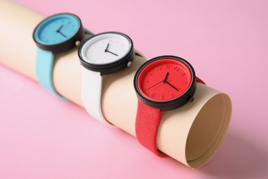 Photo of Holder with collection of stylish wrist watches on color background. Fashion accessory