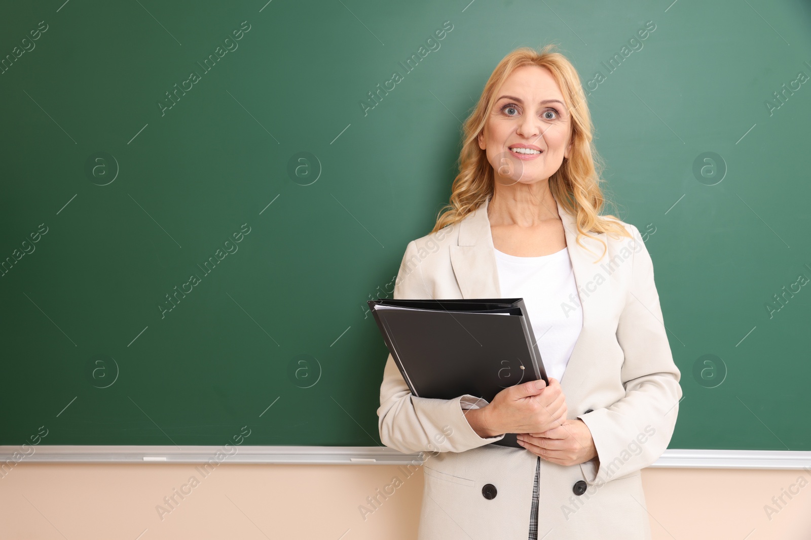 Photo of Happy professor with folders near green board, space for text