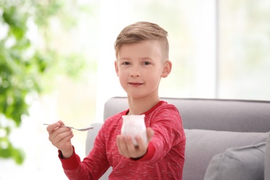 Little boy with yogurt indoors