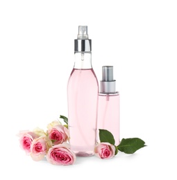 Bottles of essential oil and roses on white background