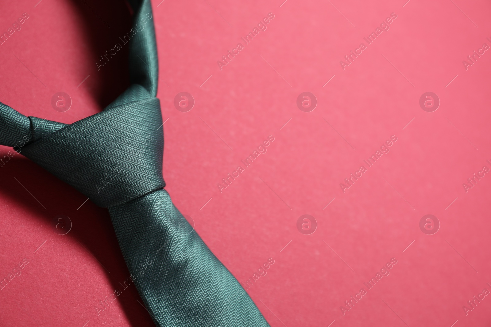 Photo of Stylish necktie on red background, closeup. Space for text