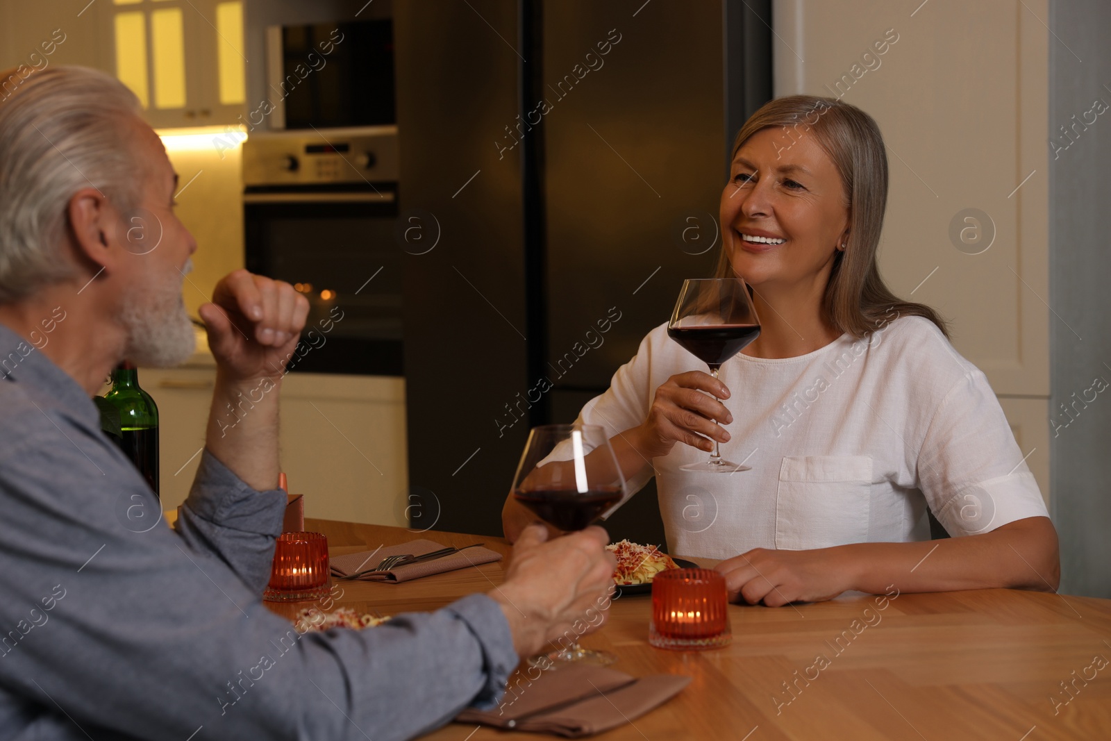 Photo of Affectionate senior couple having romantic dinner at home