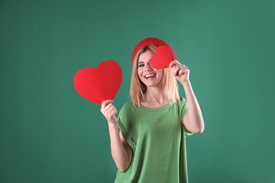 Photo of Beautiful woman with paper hearts on color background