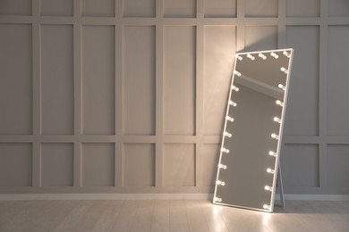 Photo of Modern mirror with light bulbs near molding wall in room, space for text