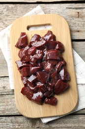 Photo of Cut raw beef liver on wooden table, top view