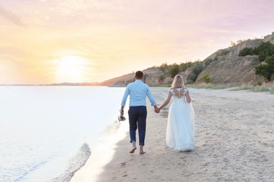 Photo of Wedding couple. Bride and groom walking on beach