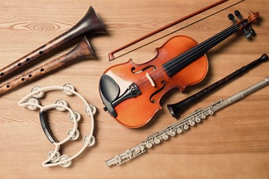 Photo of Set of different musical instruments on wooden background, flat lay