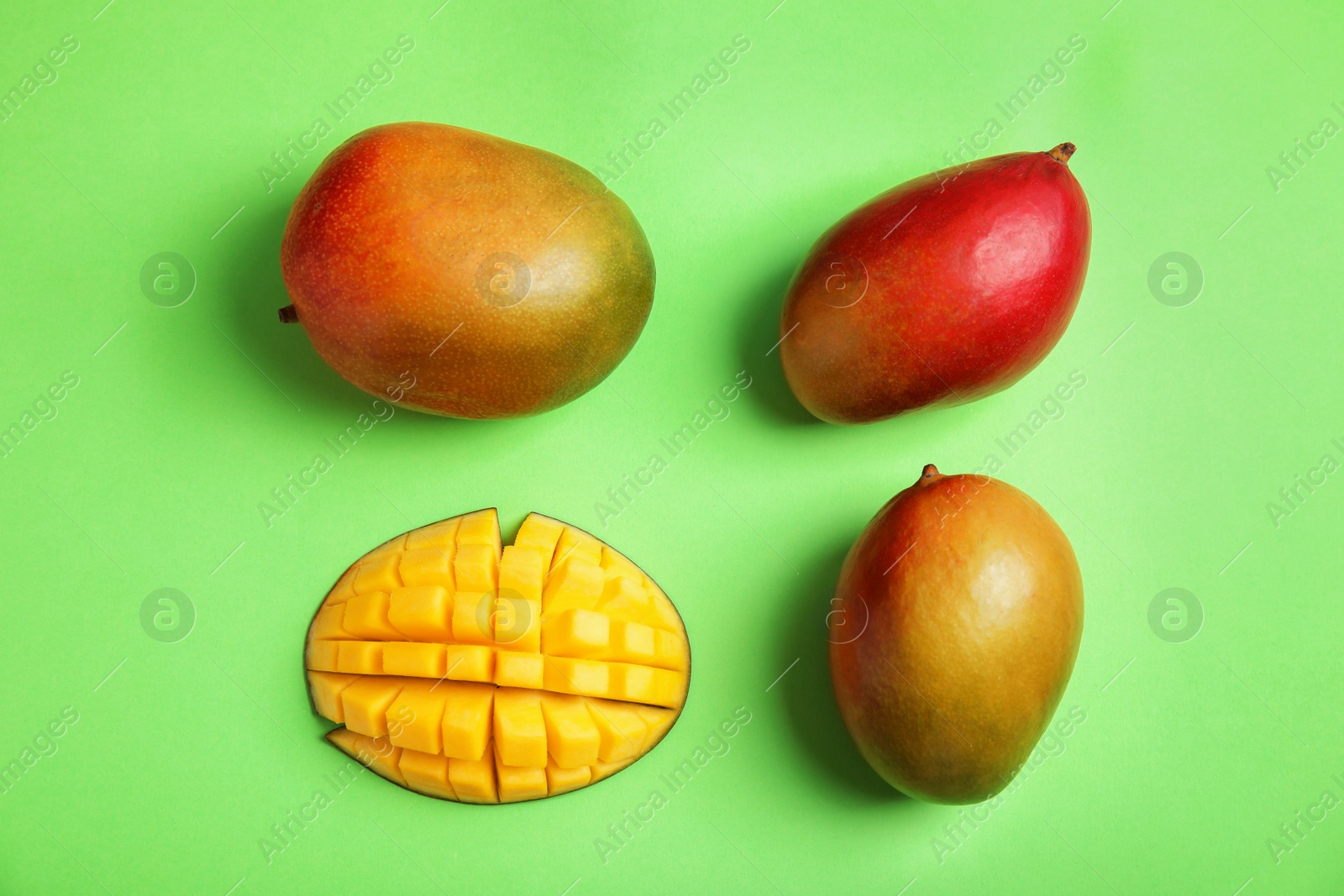 Photo of Flat lay composition with ripe mangoes on color background