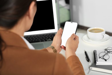 Photo of Woman using smartphone at table indoors, closeup