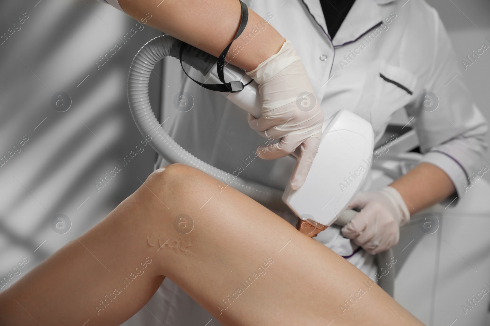 Photo of Woman undergoing laser epilation procedure in beauty salon, closeup