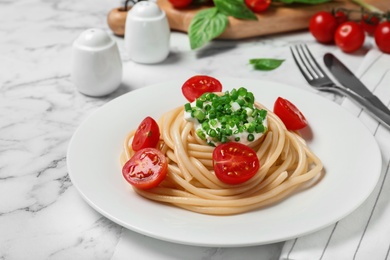 Photo of Delicious spaghetti with sour cream dressing on white marble table