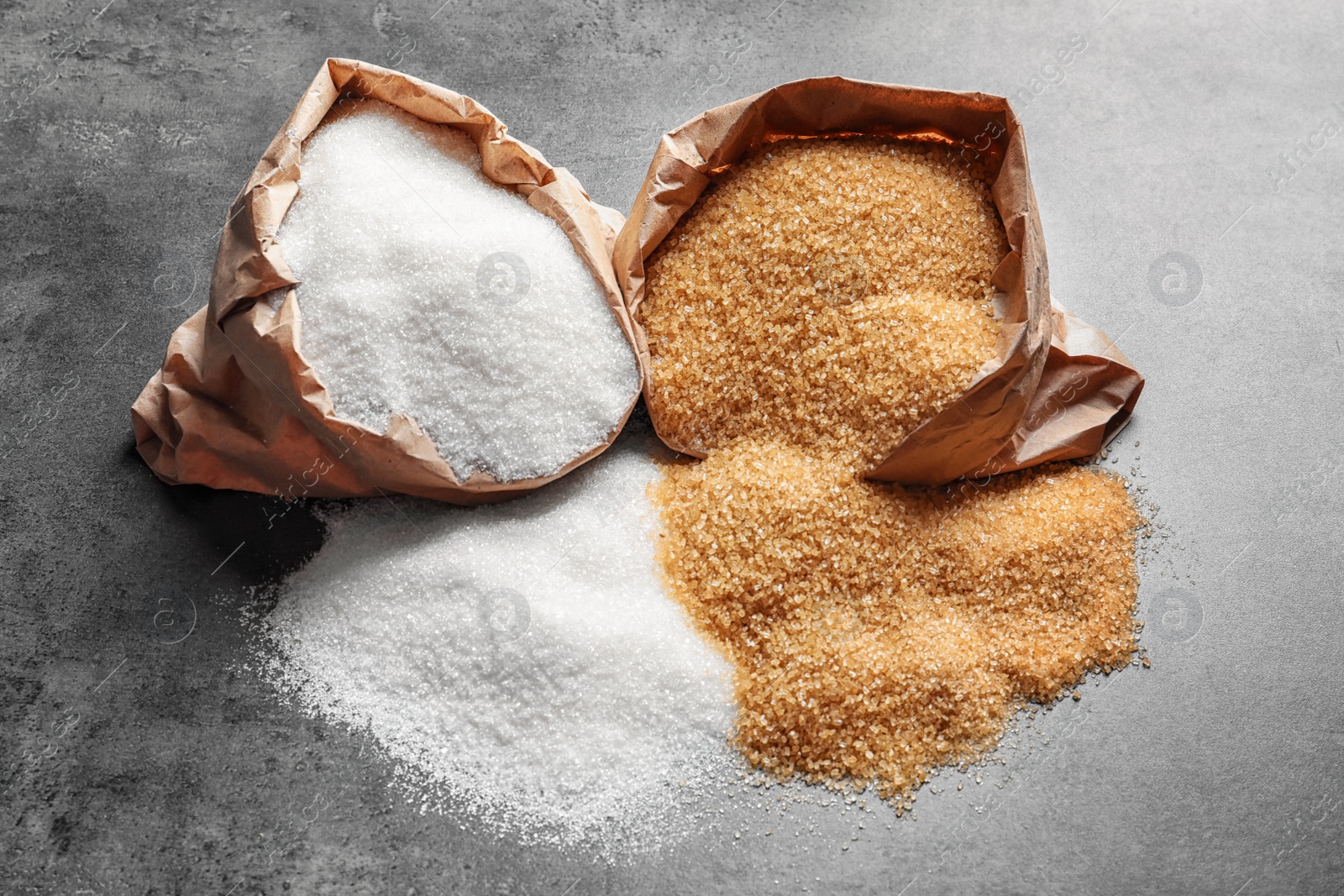 Photo of Paper bags with different types of sugar on table