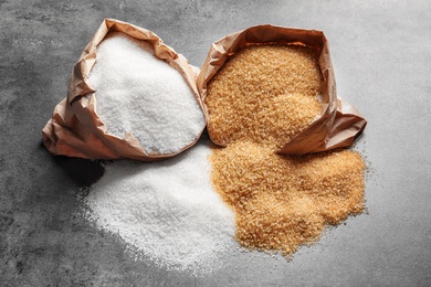 Photo of Paper bags with different types of sugar on table