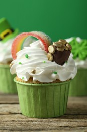 Photo of St. Patrick's day party. Tasty festively decorated cupcakes on wooden table, closeup