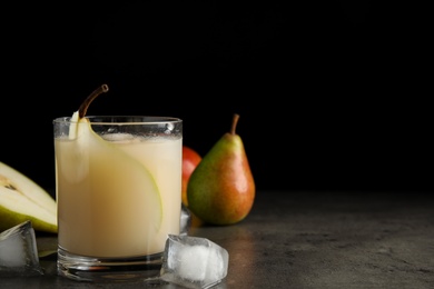 Fresh juice with pear and ice cubes on grey table. Space for text