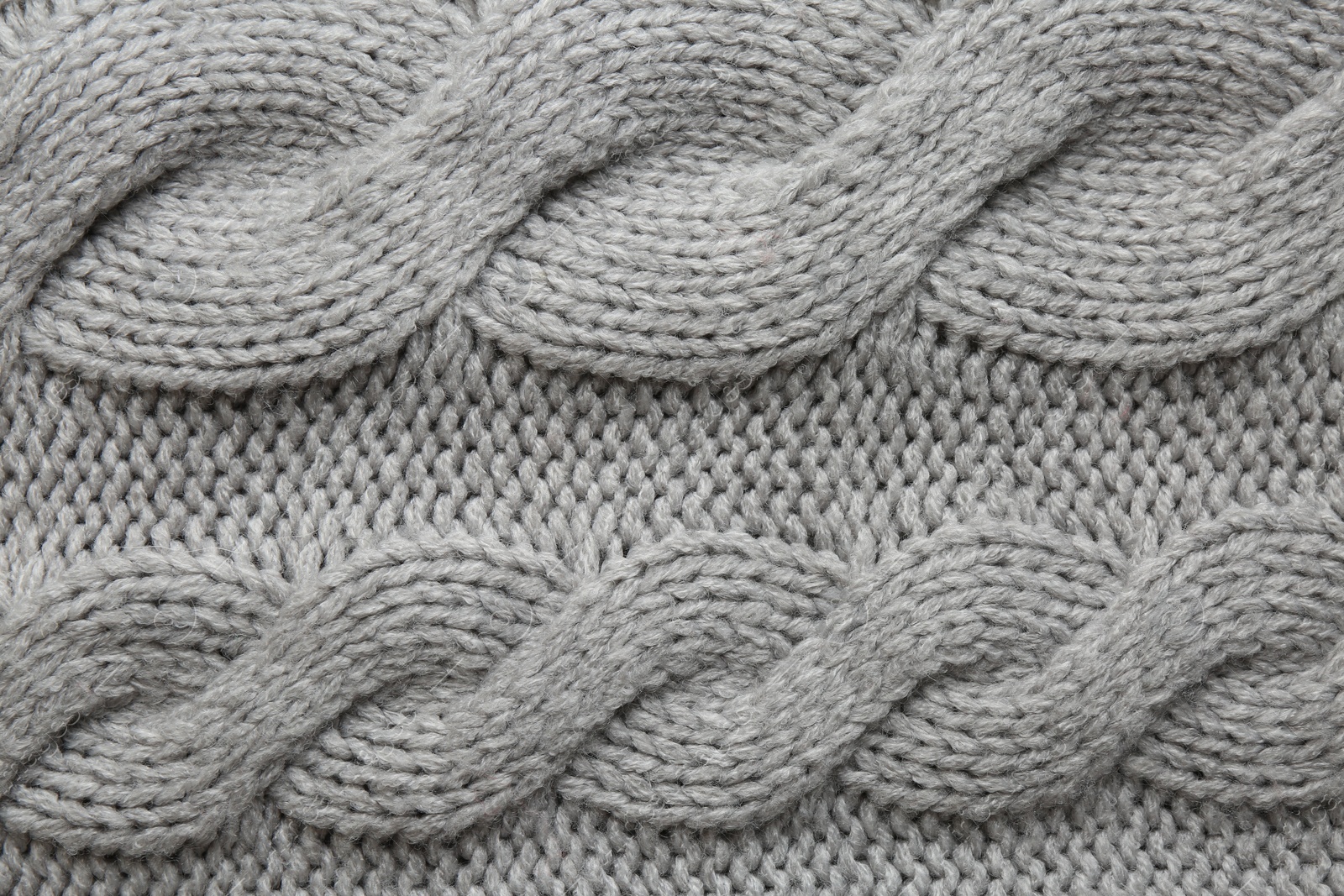 Photo of Grey knitted fabric with beautiful pattern as background, top view