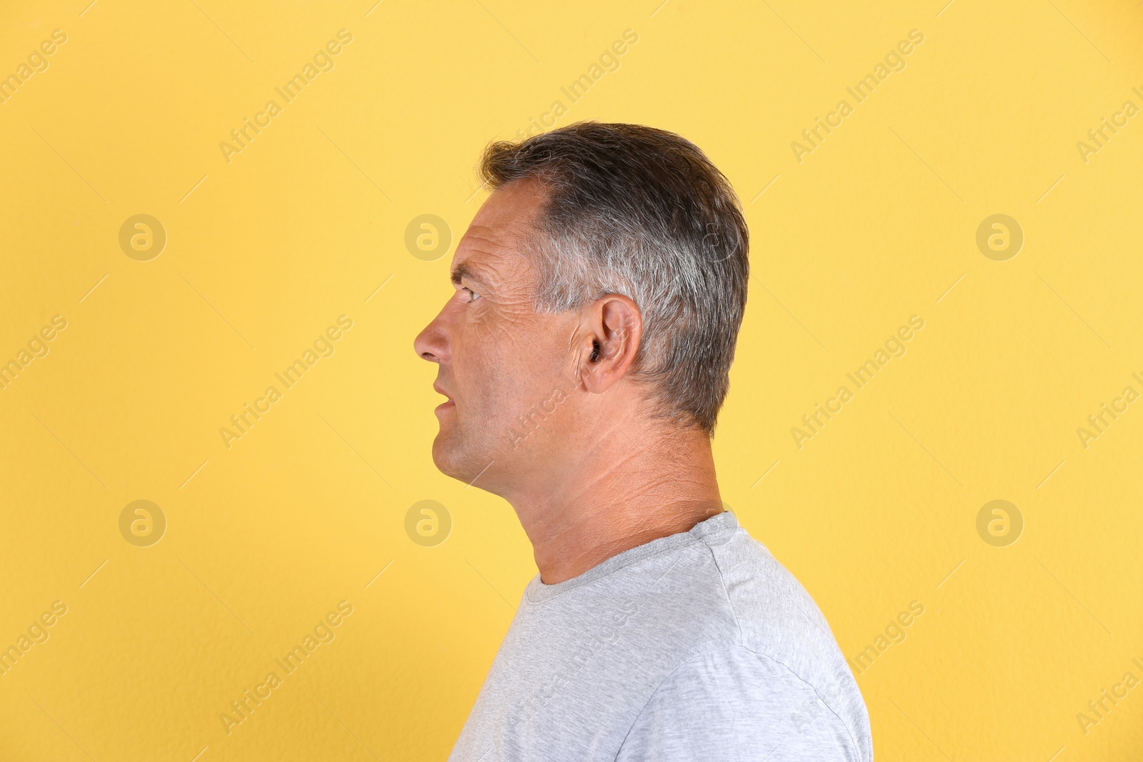 Photo of Mature man on color background. Hearing problem
