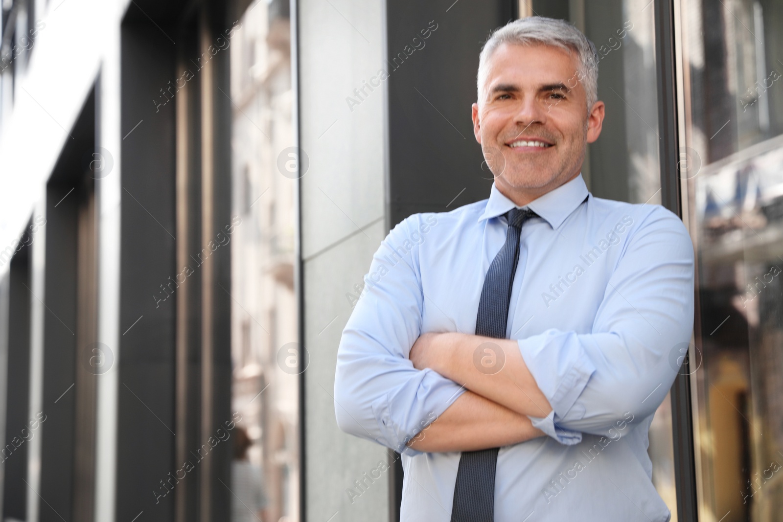 Photo of Portrait of handsome businessman in city, space for text