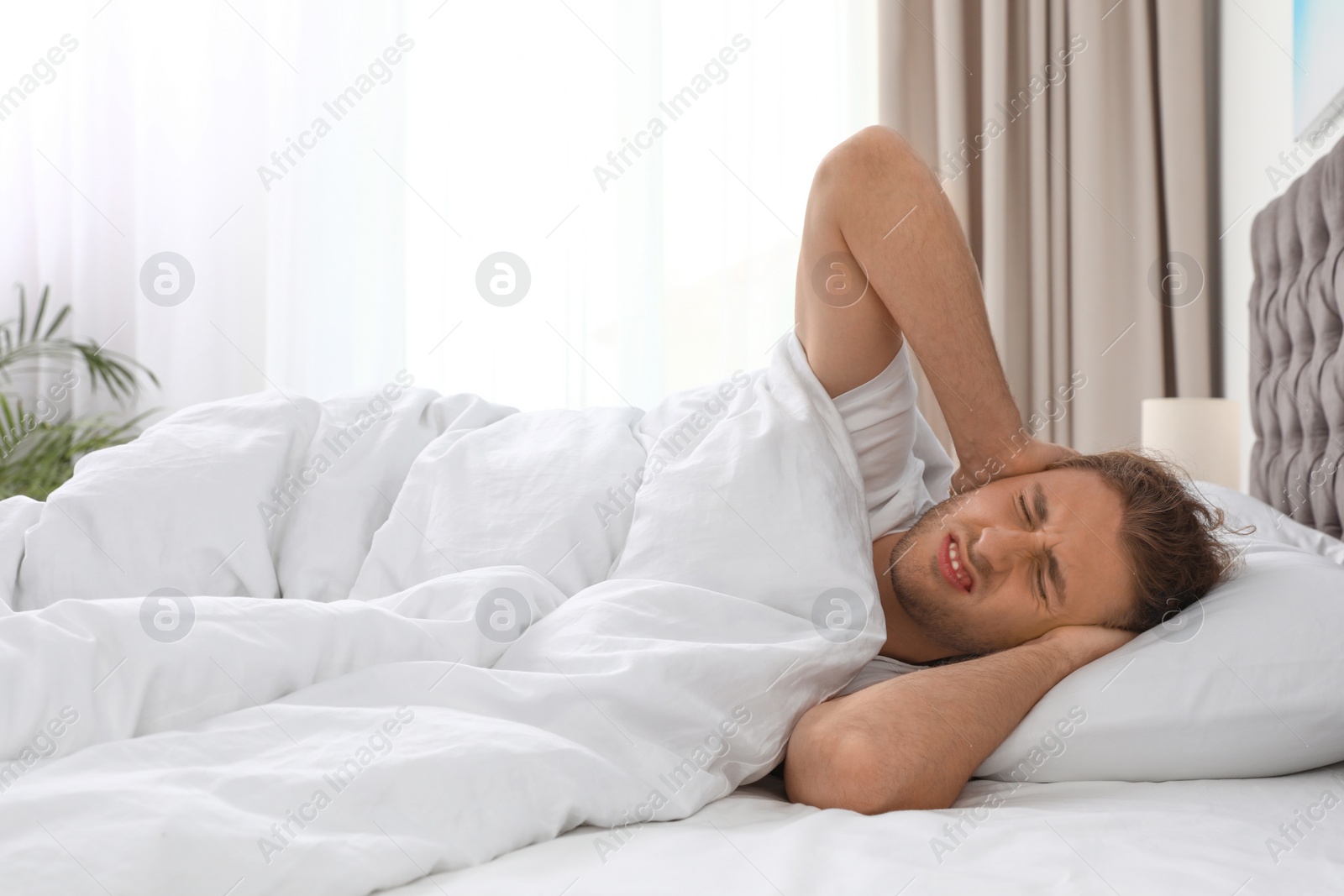 Photo of Sleepy young man lying on pillow at home. Bedtime