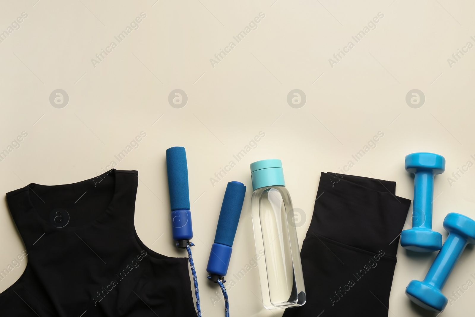Photo of Flat lay composition with sportswear and equipment on beige background, space for text. Gym workout