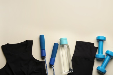 Photo of Flat lay composition with sportswear and equipment on beige background, space for text. Gym workout