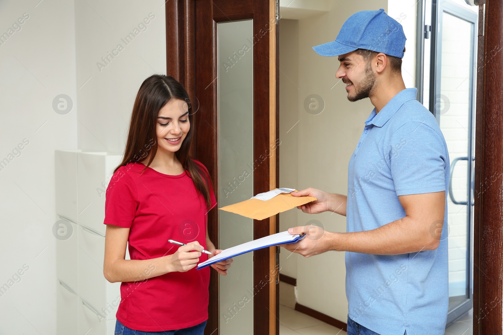 Photo of Woman receiving padded envelope from delivery service courier indoors