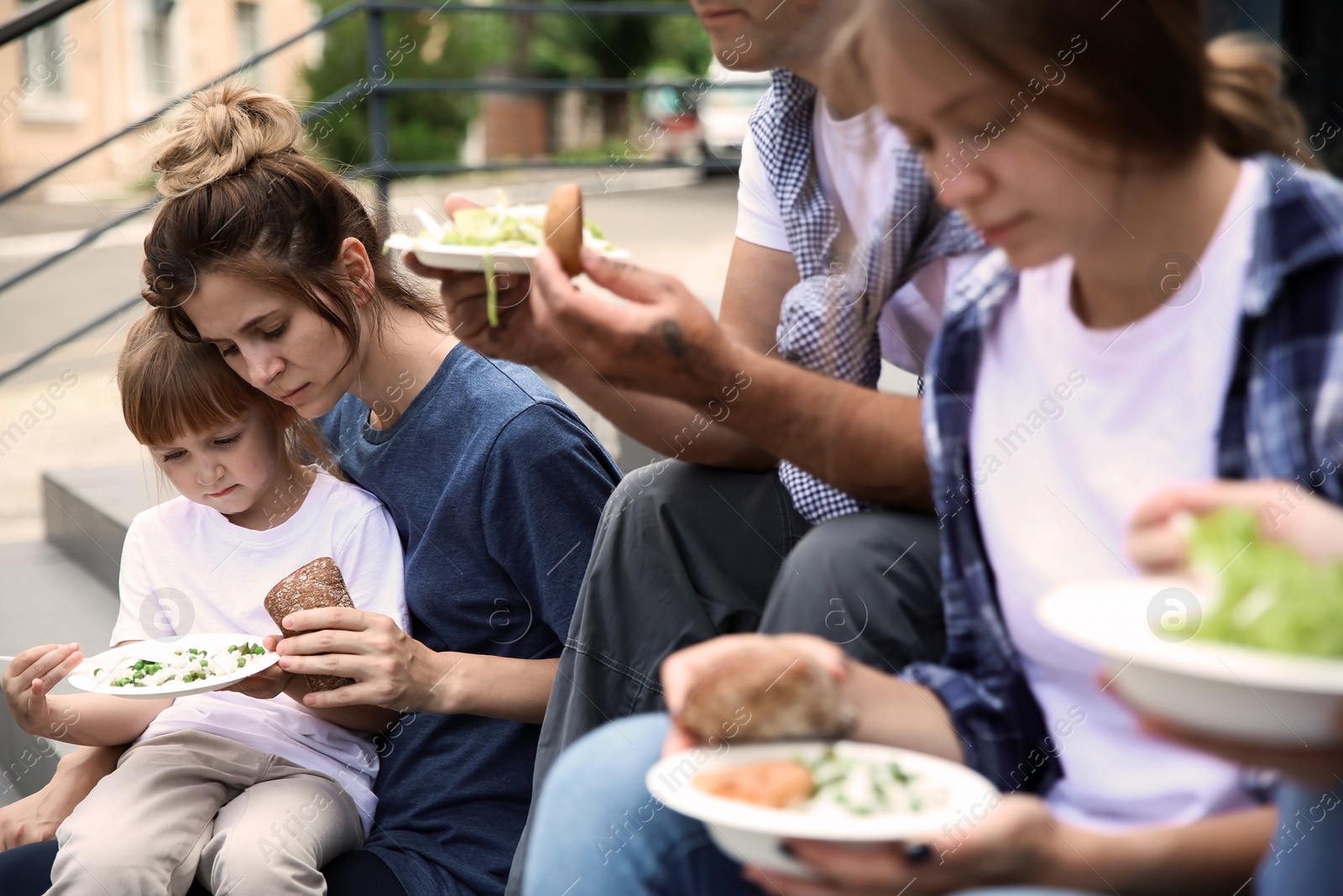 Photo of Poor people eating donated food on street