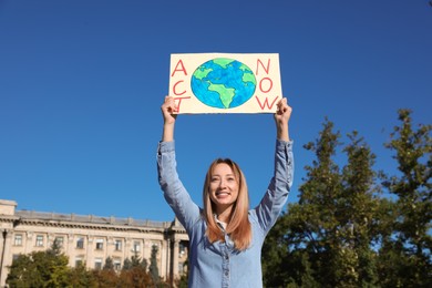 Young woman with poster protesting against climate change outdoors