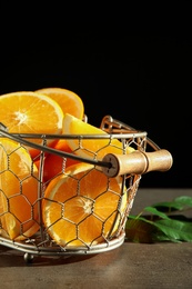 Fresh juicy oranges in basket on grey table