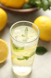 Photo of Cool freshly made lemonade in glass on light table, closeup