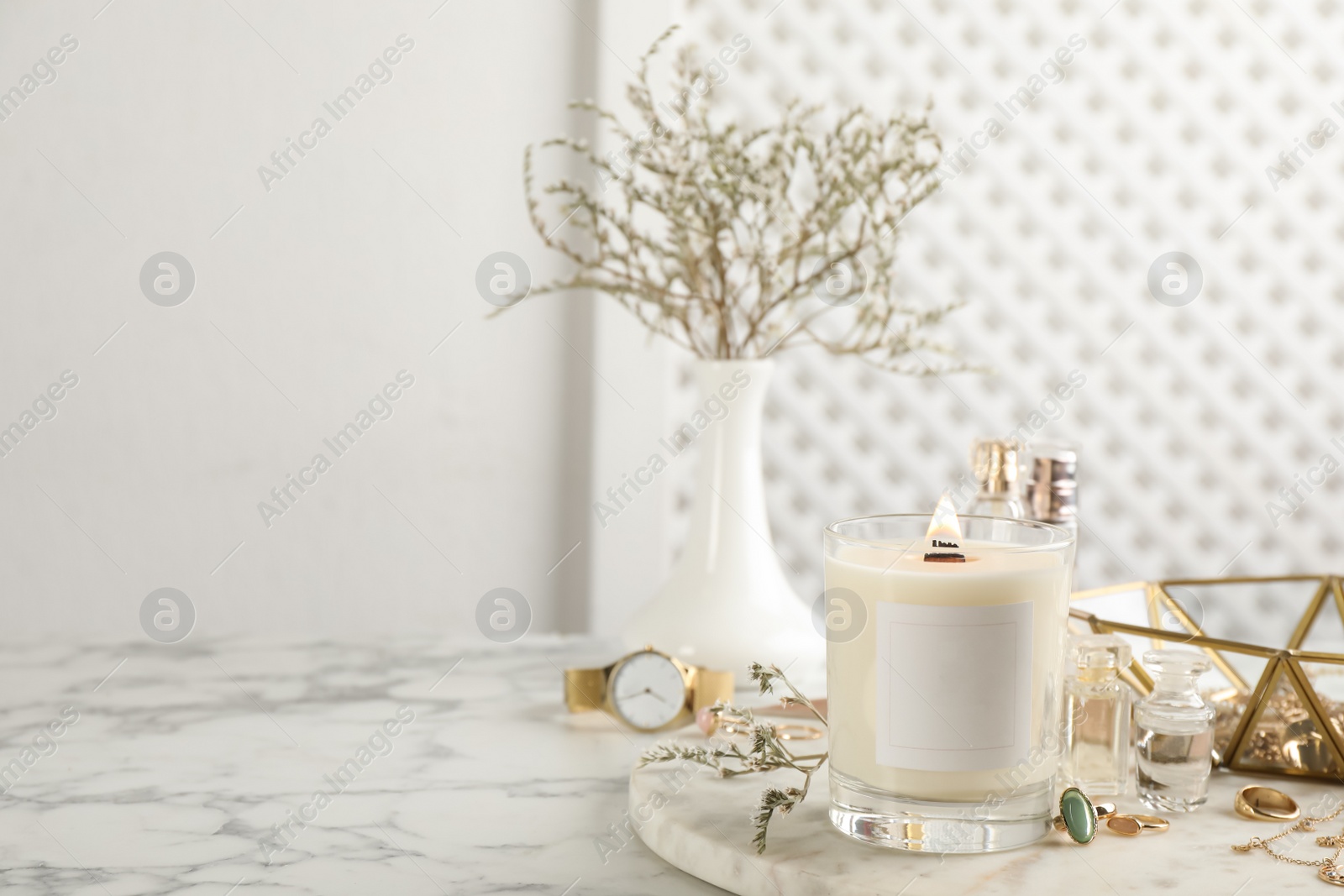 Photo of Composition with burning soy candle on white marble table, space for text