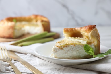 Piece of freshly baked rhubarb pie with cream cheese and cutlery on table, closeup