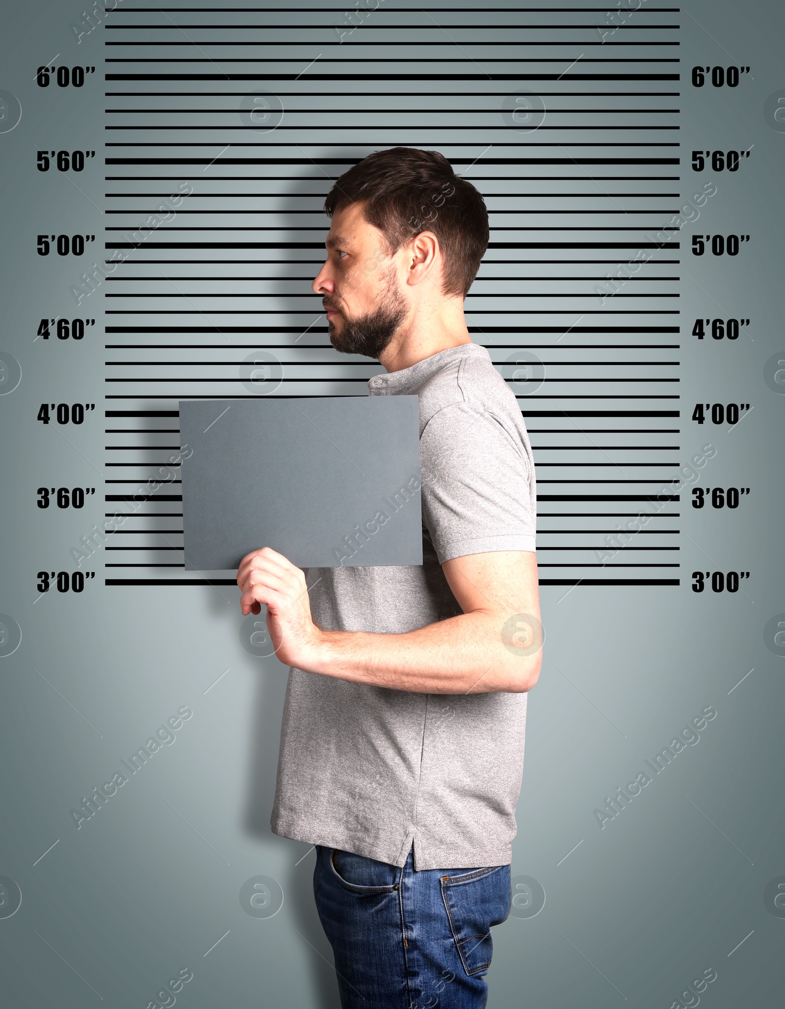 Image of Criminal mugshot. Arrested man with blank card against height chart